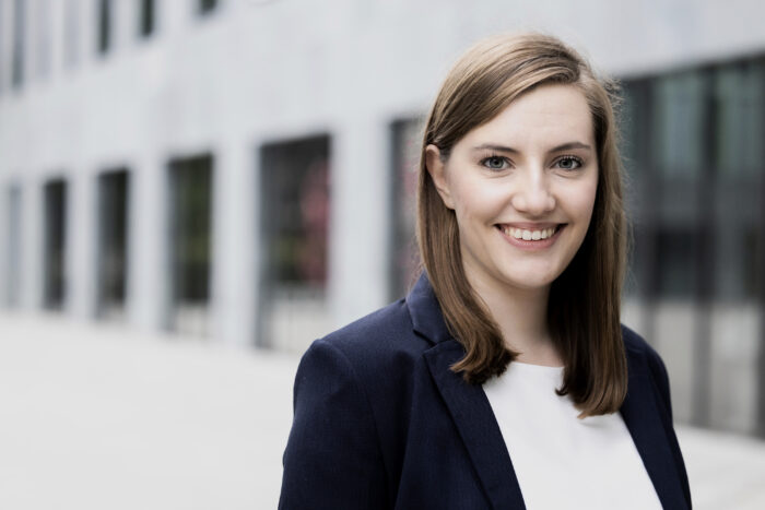 Bewerbungsfoto mit Gebäude im Hintergrund